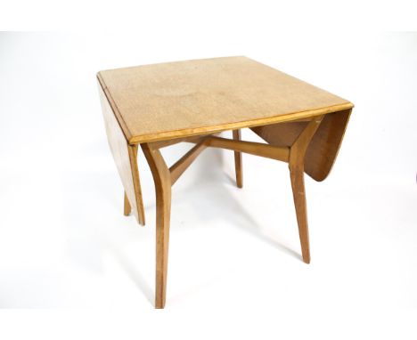 A mid-century light oak drop leaf dining table. Of rectangular form, with a moulded edge on square tapering supports with a c