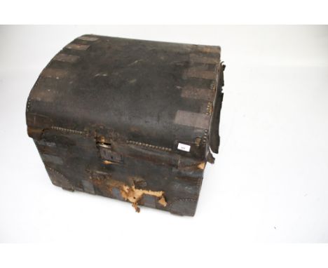 A vintage domed-top trunk. Covered in leather with a paper lined interior, previous lock and remnants of handle present, H57c