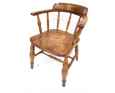 A vintage smoker bow elm open armchair. Raised on turned tapering supports with twin stretchers. H77cm