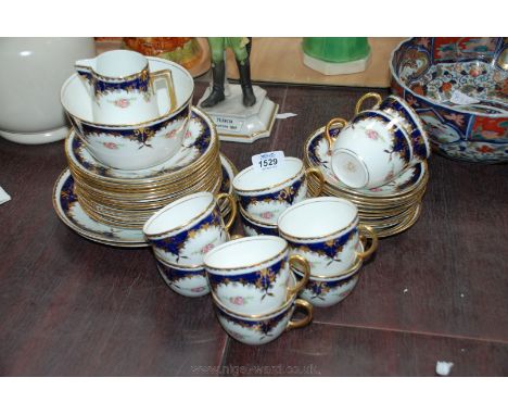 A ''Queens China'' Teaset, white ground decorated with rose sprays with a dark blue and gilt border and comprising of ten Cup