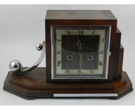 An Art Deco stepped mahogany mantle clock, having Roman Numeral dial.