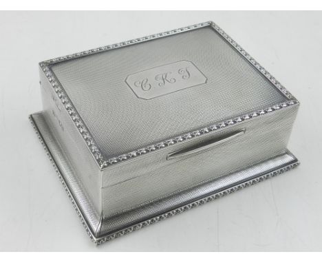 An Art Deco silver cigarette box, with engine turned design, hallmarked London 1910, by Mappin & Webb, weighs 13oz.