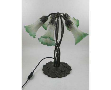 An Art Nouveau style cast metal table lamp, with four glass shades in form of flowers, the wrythen stems raised on floral bas