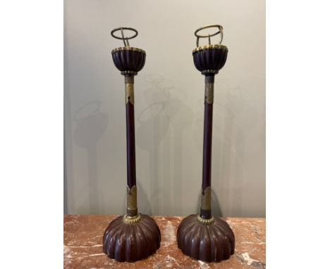 A pair of lacquered wood candlesticks (18th century), each with a large, solid hemispherical base that is carved in the form 