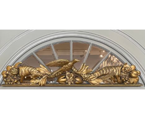 An 18/19th century carved and gilded over-door, from a house in Yorkshire. With a bird in the centre flanked by a pair of cor