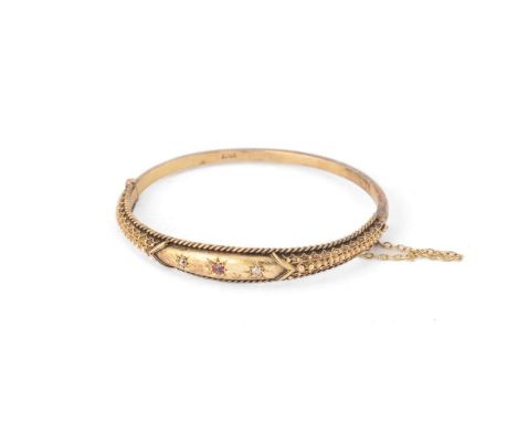 15ct gold hinged bangle, set ruby and diamonds, with safety chain, stamped '15ct', rope border, 11.1g.