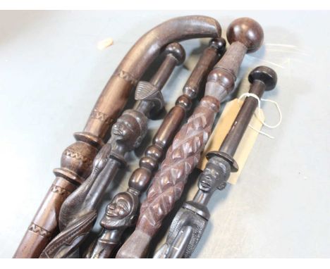 An African tribal type walking stick, carved with a male child's head, the shaft carved with an entwined serpent, length 98cm
