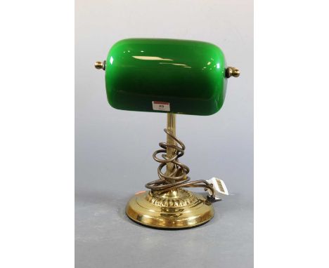 A lacquered brass desk lamp having adjustable green tinted glass shade