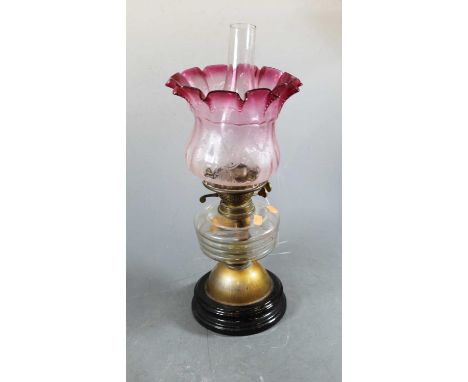 A 19th century glass oil lamp, the cranberry tinted and acid etched shade above a clear glass font, 52cm high overallConditio