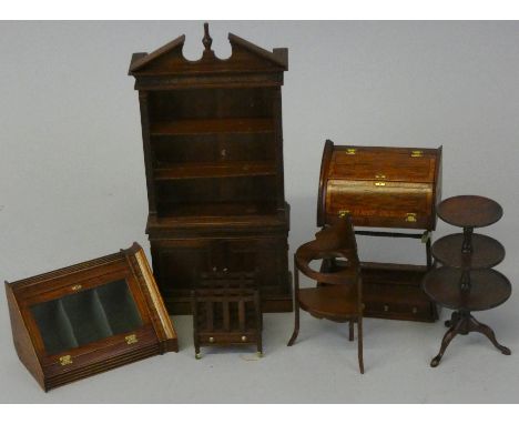 A collection of dolls house furniture signed Dennis Jacobs, including tall bookcase with finial top, £102 sticker to reverse,