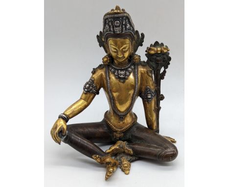 A Nepalese seated Deity Indra figure in gilded bronze and applied silver, Nepal, circa 1900, H.16cm