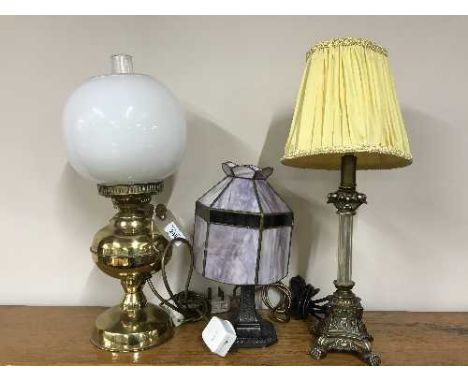 A converted brass oil lamp, a table lamp and a metal table lamp with leaded shade 