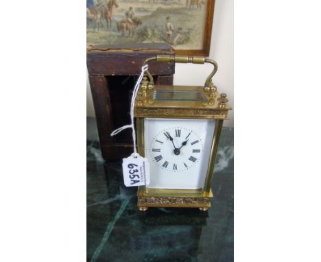 A Brass Carriage Clock, the enamelled dial bearing Roman numerals in original leather case with key, 15cm (handle up).