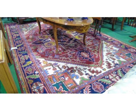 A Persian Style Wool Carpet, with deep red field and abstract decoration within alternating borders, 300cm x 200cm.