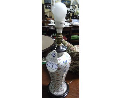 An Oriental Table Lamp, having floral and gold painted decoration standing on a turned hand painted base.