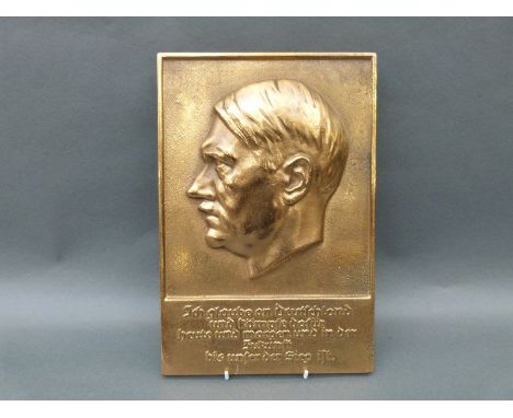 A German brass or bronze plaque of Adolf Hitler with motto below, 32 x 21cm 