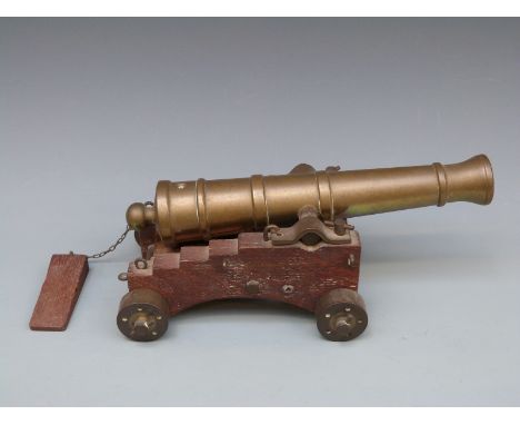 A late 19th/early 20thC bronze desk cannon and wooden carriage with bronze wheels with 10 inch multi-stage ribbed barrel flar