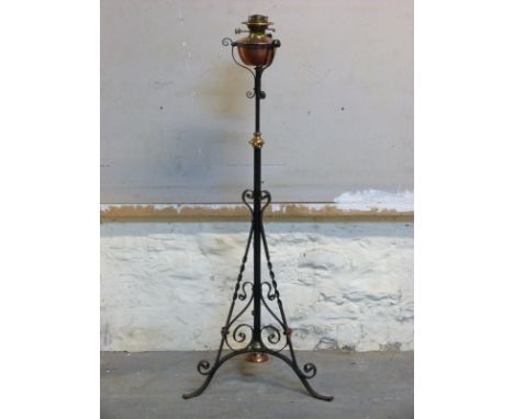A 19thC Arts and Crafts style Evered & Co copper and brass oil lamp on wrought iron adjustable height base 