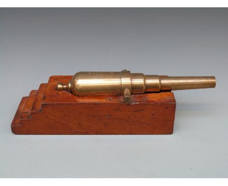 A 19thC bronze cannon with 10.5 inch multi-stage barrel raised on fitted mahogany base, overall length 38cm