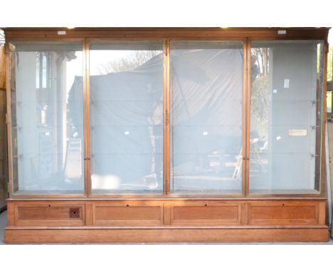 Ex Victoria & Albert Museum early 20thC four door glass display cabinet with bronzed frame, on mahogany base with provision f