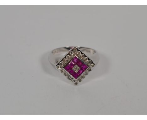 A ruby and diamond cluster ring, stamped 'K18', finger size N.  Gross weight - 3.7 grams. 