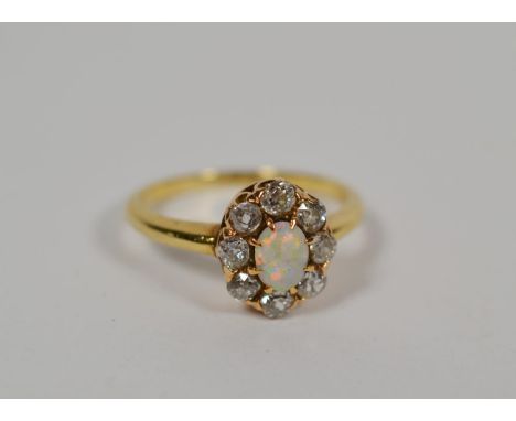 An opal and diamond cluster ring, total estimated diamond weight 0.40 carat approximately, finger size N.  The ring is in goo