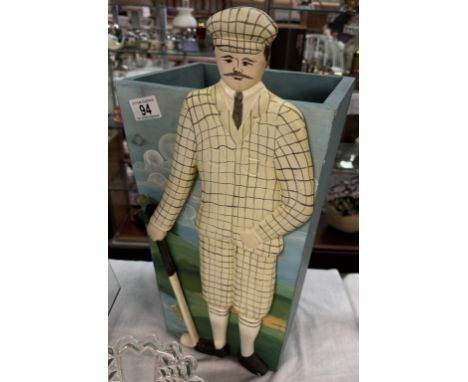 A wooden stick/umbrella stand featuring a figure of a golfer