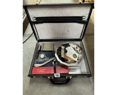 A briefcase &amp; contents including two five pound coins, crowns, pens, silver plated cigarette box etc