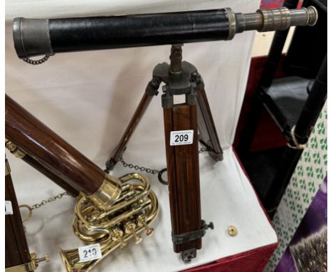 A patinated brass telescope on hardwood tripod base