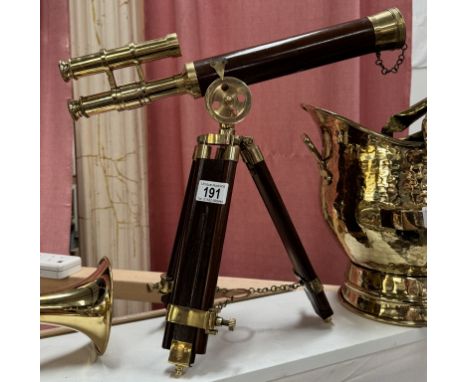 A brass telescope on hardwood tripod base