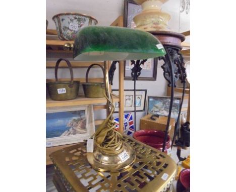 A brass bankers lamp with green glass shade. 