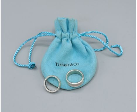A Tiffany 925 silver band ring, size L together with another similar 925 silver band ring by Tiffany, ring size J, complete w