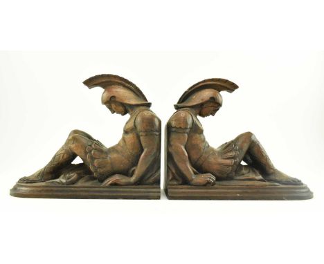 A pair of vintage early to mid 20th century carved wooden bookends in the form of seated Roman gladiators. Each bookend forme