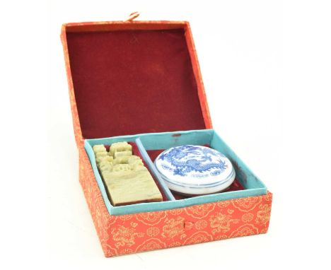 A soapstone carved seal and a blue and white seal box set. The set to include a soapstone carved Lion and a cub standing on a
