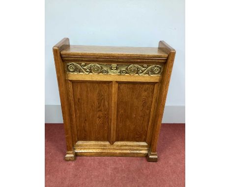 A XX Century Oak Book Stand, with a slightly sloping top and frieze with winged angel and scroll decoration, side supports wi