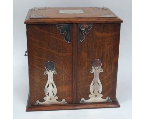 An Early XX Century Oak Cased Smokers Cabinet, of rectangular form with plated mounts and side carrying handles, the double d