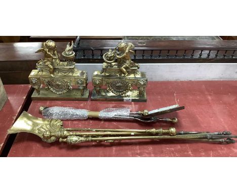 A Pair of Late XIX Century French Style Gilt Brass Andirons, each surmounted by a winged putto, and six brass fire tools. (8)