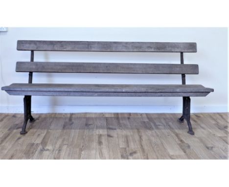 19th century railway or garden bench with hinged wooden seat & wooden back rails on foliate pierced cast iron supports.   Con