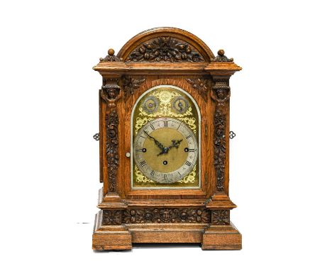 A Victorian Carved Oak Chiming Table Clock, retailed by Horner, Halifax, circa 1890, arched pediment, floral and figural carv