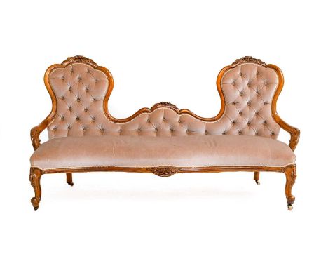 A Victorian Walnut-Framed Three-Seater Sofa, circa 1880, recovered in buttoned brown velvet, the moulded frame surmounted by 