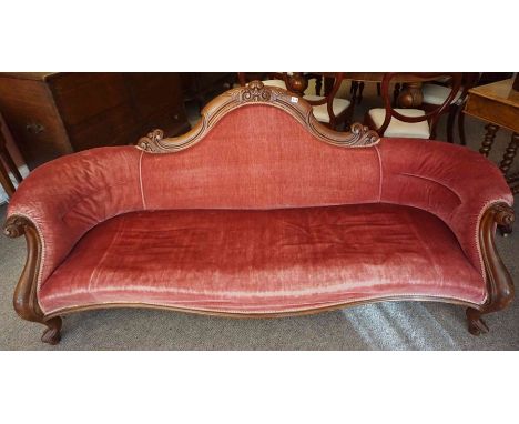 A Victorian Mahogany Framed Scroll End Sofa, Upholstered in later pink velour, having a serpentine shaped front, raised on sc