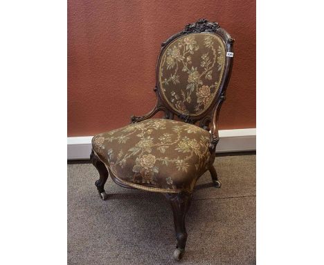 A Victorian Mahogany Ladies Parlour Chair, Having a spoon shaped back rest, serpentine front, upholstered in later floral fab