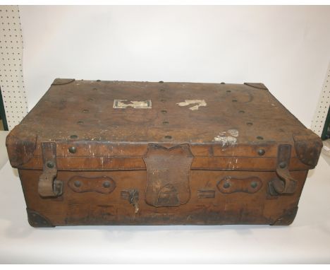 LARGE VINTAGE LEATHER TRUNK a large trunk with a secure lever brass lock and carrying handles on both sides, with various vin