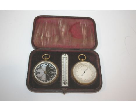 CASED POCKET BAROMETER/THERMOMETER & COMPASS a fitted leather case containing a pocket barometer and compass, both with brass