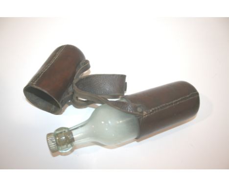 LEATHER CASED SADDLE BOTTLE a leather case containing a Mackinlay's Scotch Whiskies glass bottle. The case with a leather str