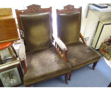 A pair of Victorian carved walnut His and Hers open armchairs having upholstered seats, backs and armrests in a dark green fa