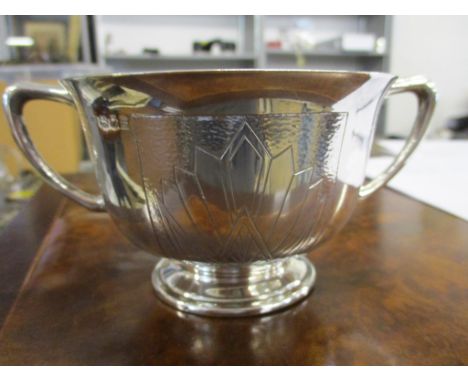 A silver twin handled sugar bowl on a pedestal foot with engraved and spot hammered decoration, 4 1/4" dia, 219g 