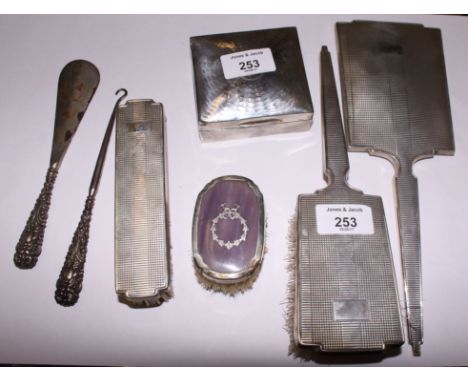 A silver three-piece dressing table set, a small silver mounted clothes brush, a silver cigarette box, a silver handled butto