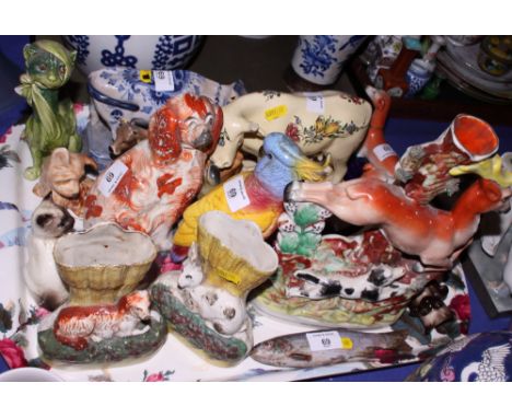 A pair of 19th Century Staffordshire greyhound inkwells for restoration, two floral decorated cattle, a Delftware cow and a n
