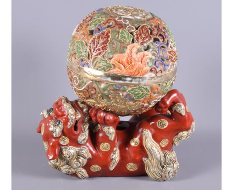 A Japanese polychrome enamelled lamp base, formed as a Dog of Fo balancing a ball, 8 1/2" high 